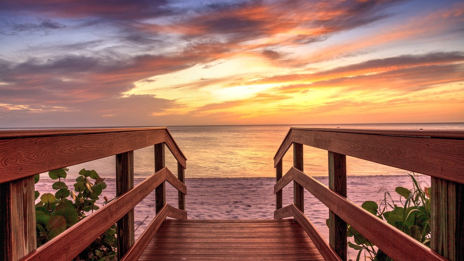 A boardwalk to the beach at sunset